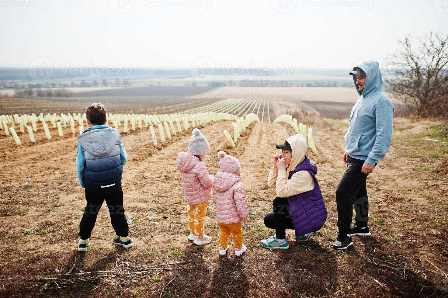 Family stand against vineyard in early spring. photo