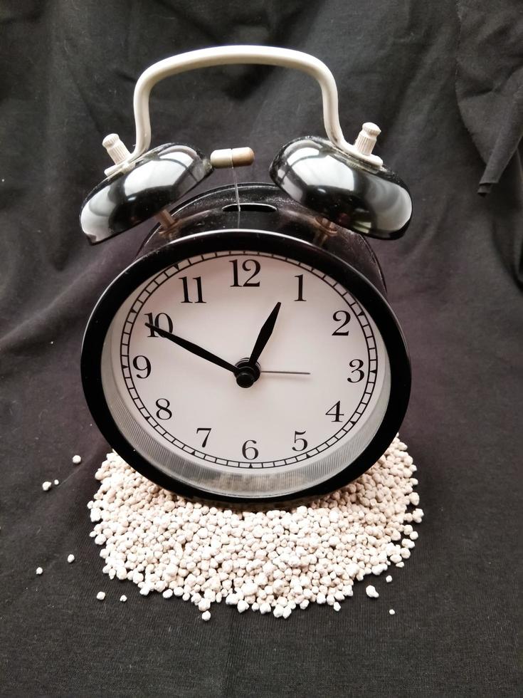 classic black alarm clock on black background photo