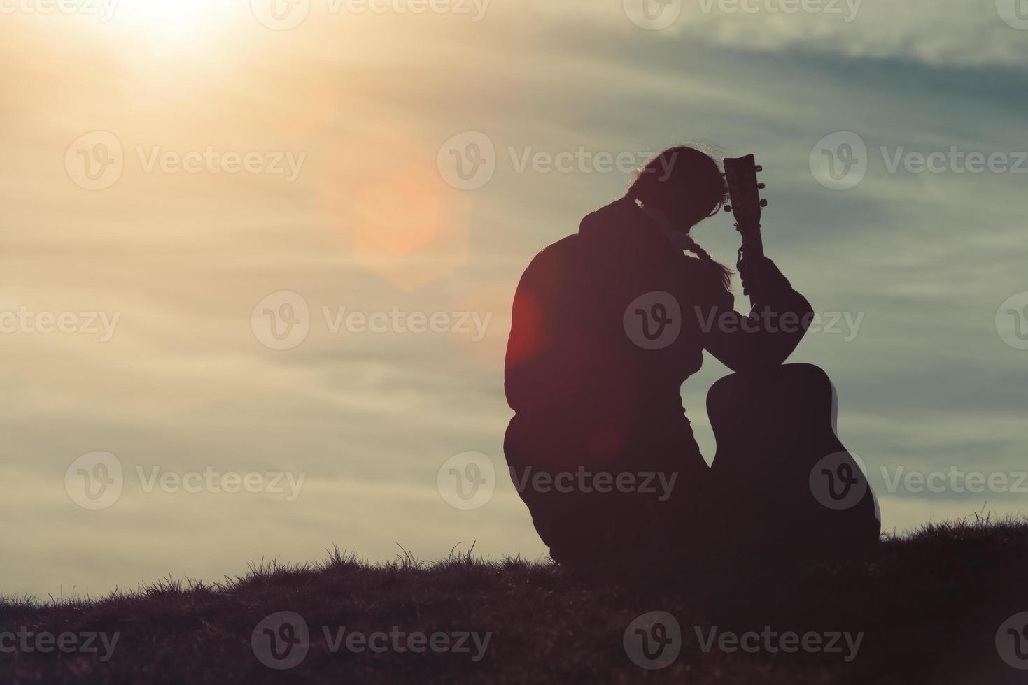 Girl with guitar in the grass photo