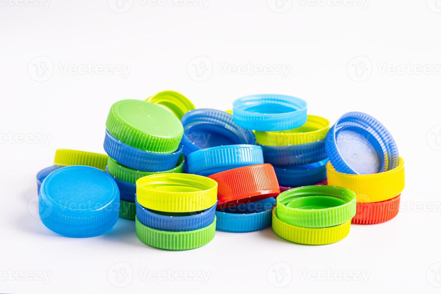 Plastic bottle colored screw caps for recycle waste on white background, container water lid. photo