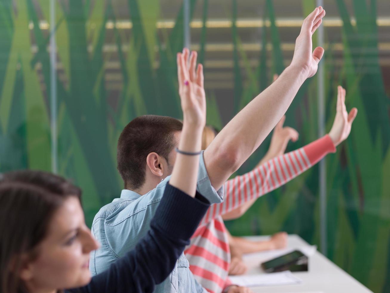 grupo de estudiantes levantan la mano en clase foto