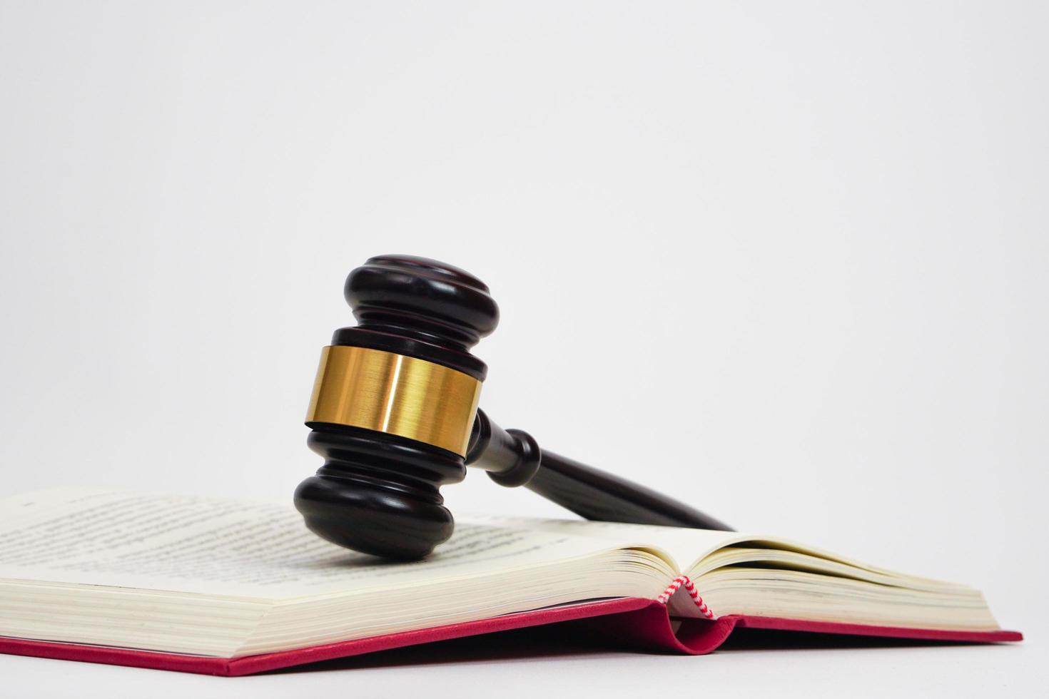 Close up of judge gavel on law book in white background. Lawyer, law, justice system, hammer auction. photo