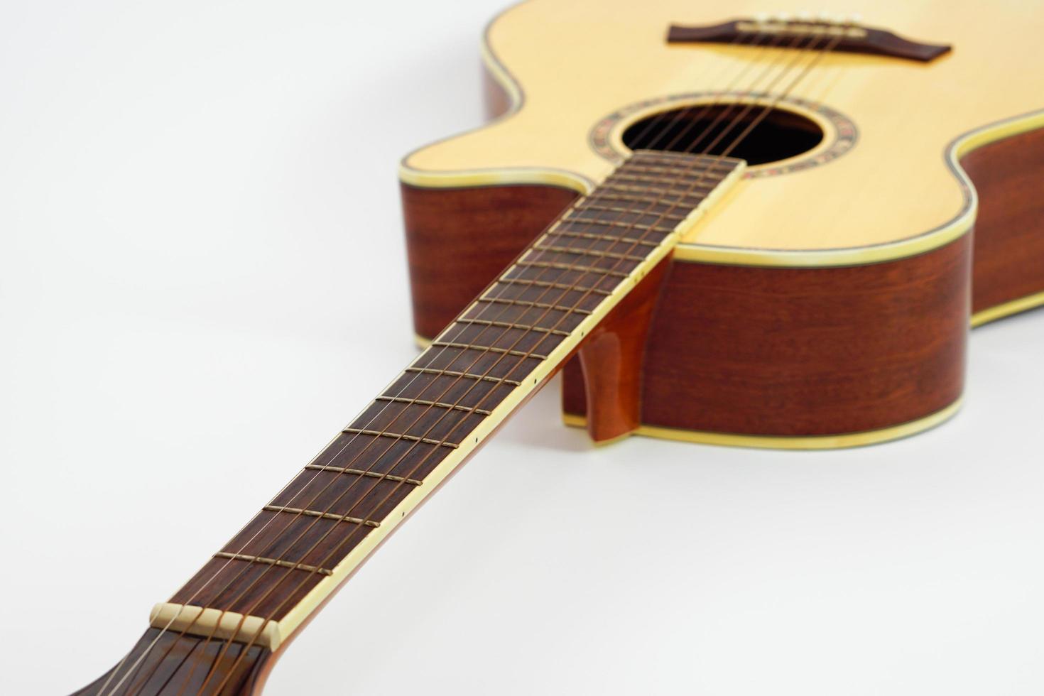 An acoustic guitar on white background with copy space and selective focus. photo