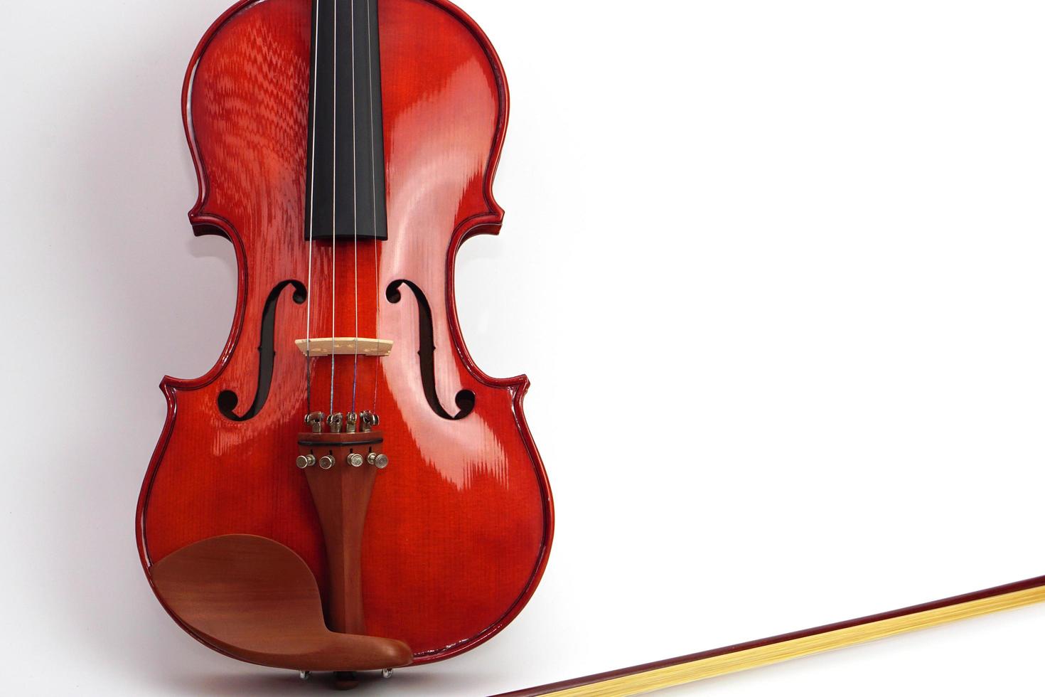 violín apoyado contra un fondo blanco de pared en blanco con espacio de copia. instrumento y concepto musical. foto