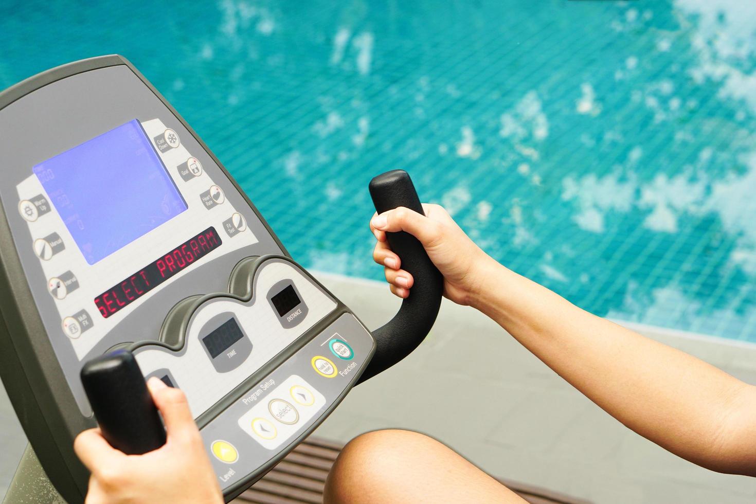 primer plano de la mano que sostiene una máquina de ejercicio de bicicleta eléctrica en fitness. foto