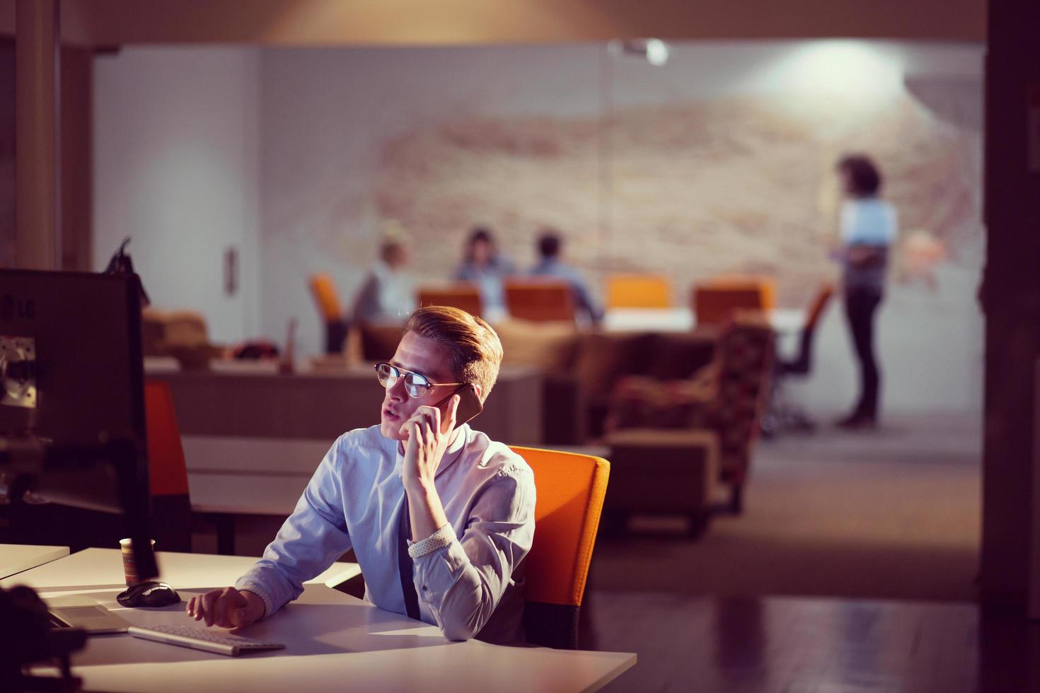 man using mobile phone in dark office photo