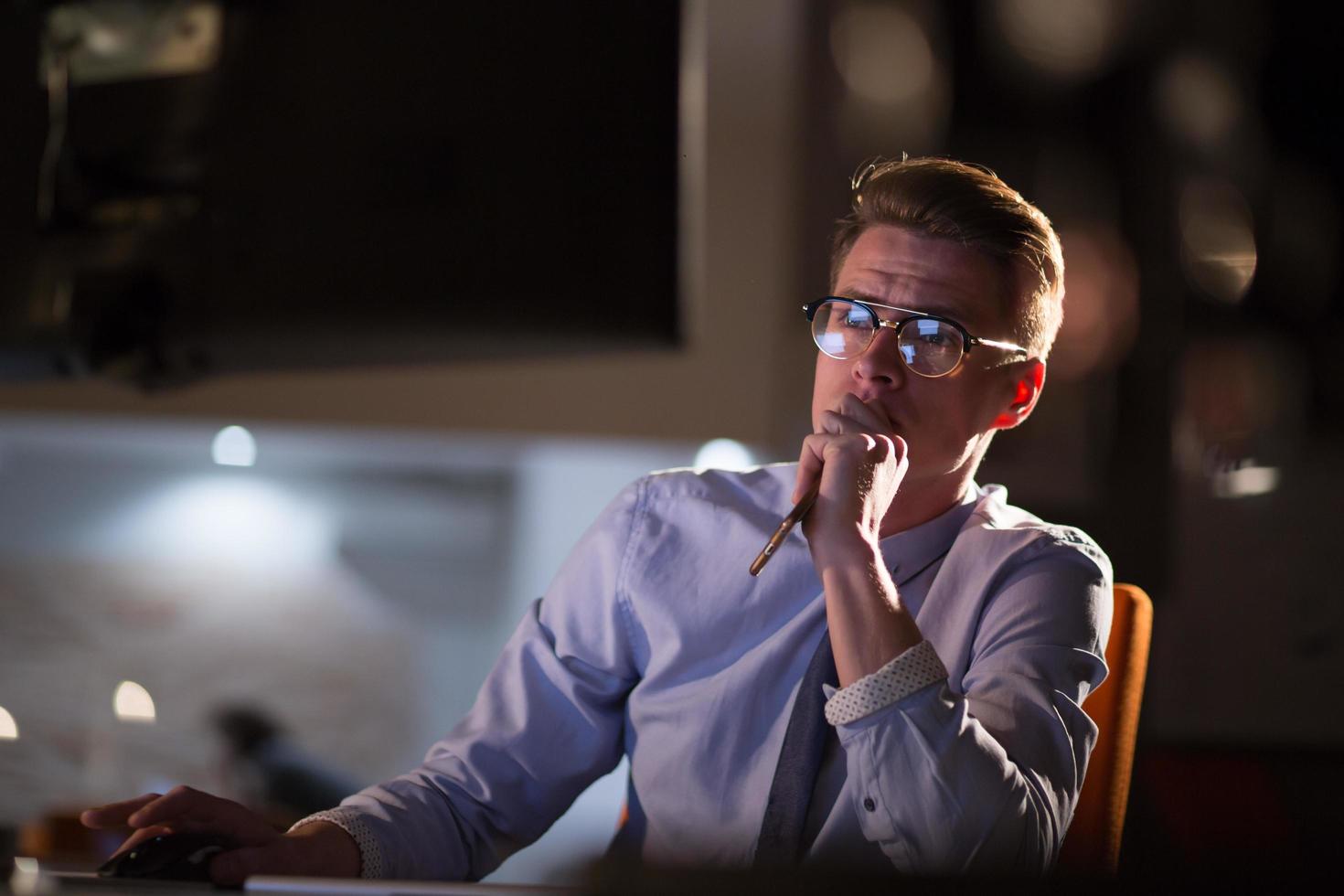 man working on computer in dark office photo