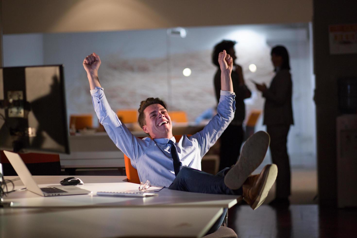 businessman sitting with legs on desk at office photo