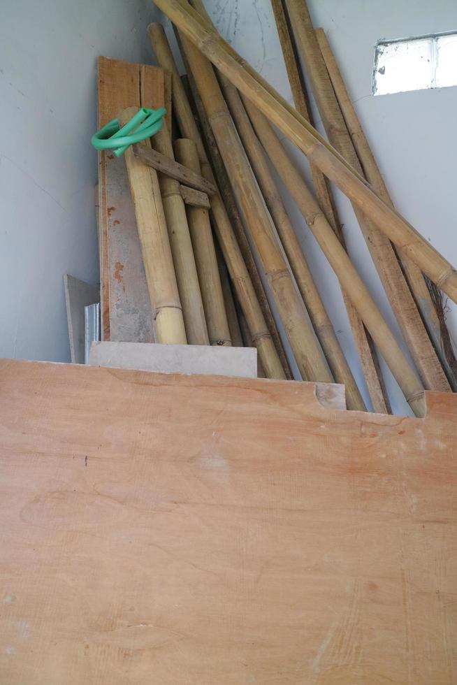 pile of used boards and bamboo in the corner of the room photo