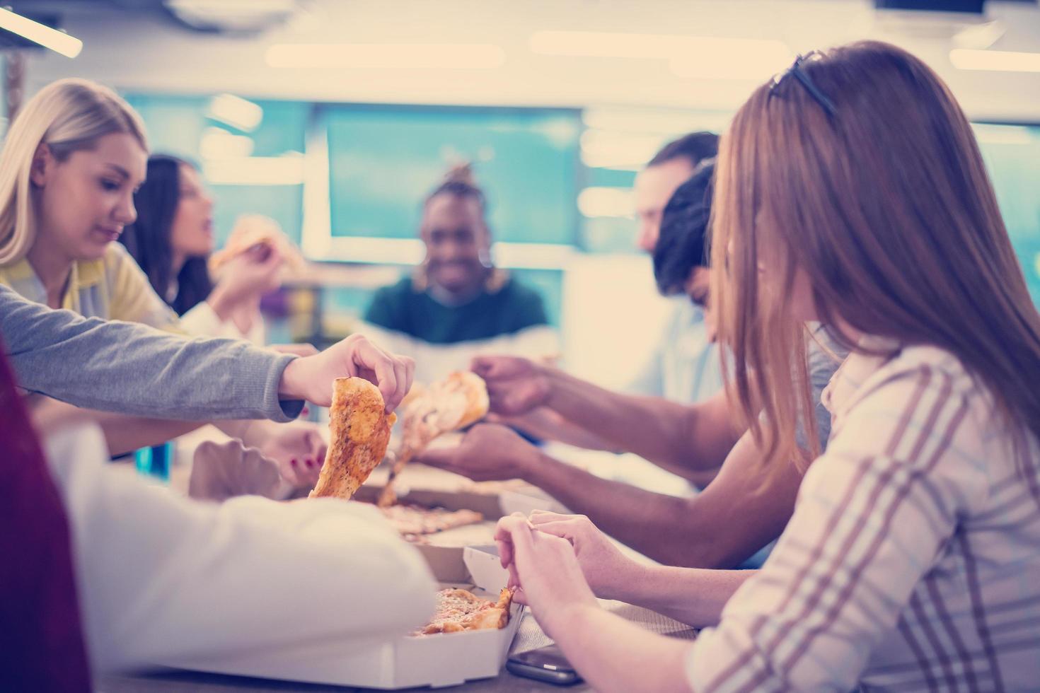 multiethnic business team eating pizza photo