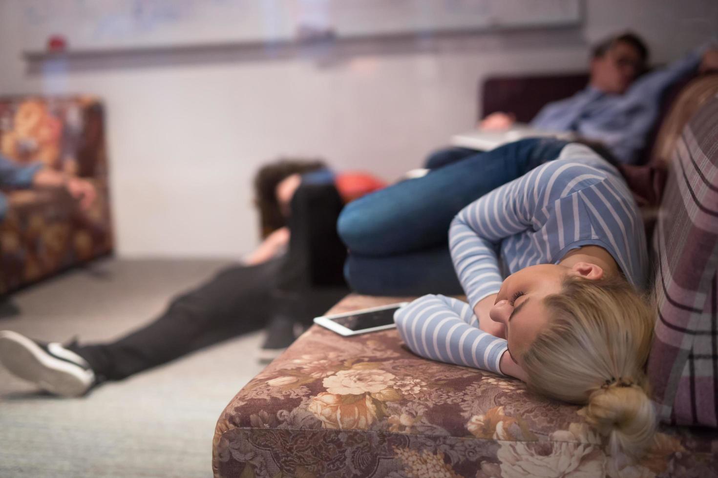 software developers sleeping on sofa in creative startup office photo