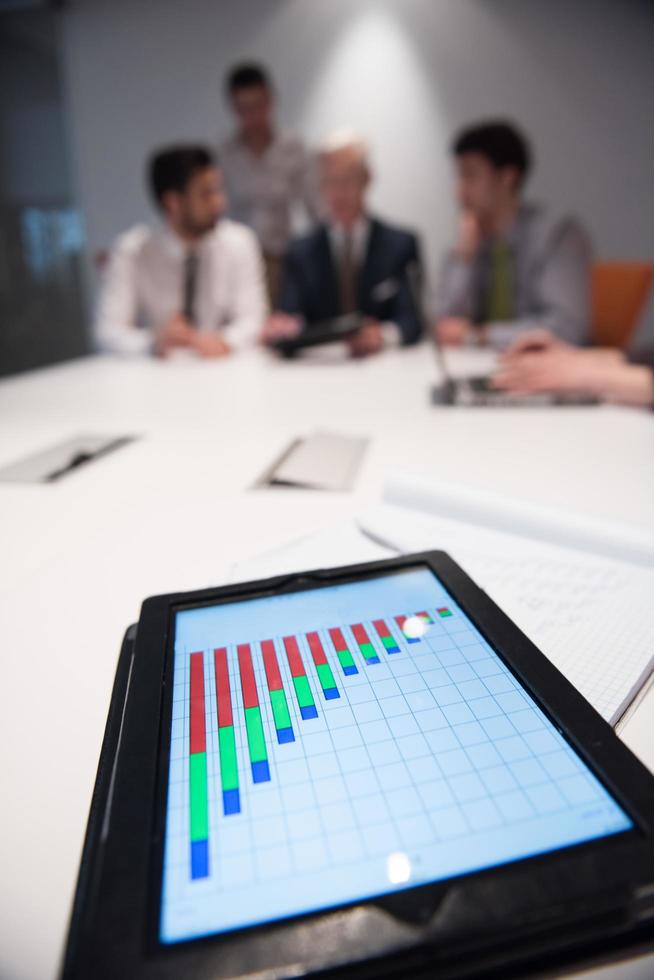 close up of touchpad with analytics documents at business meeting photo