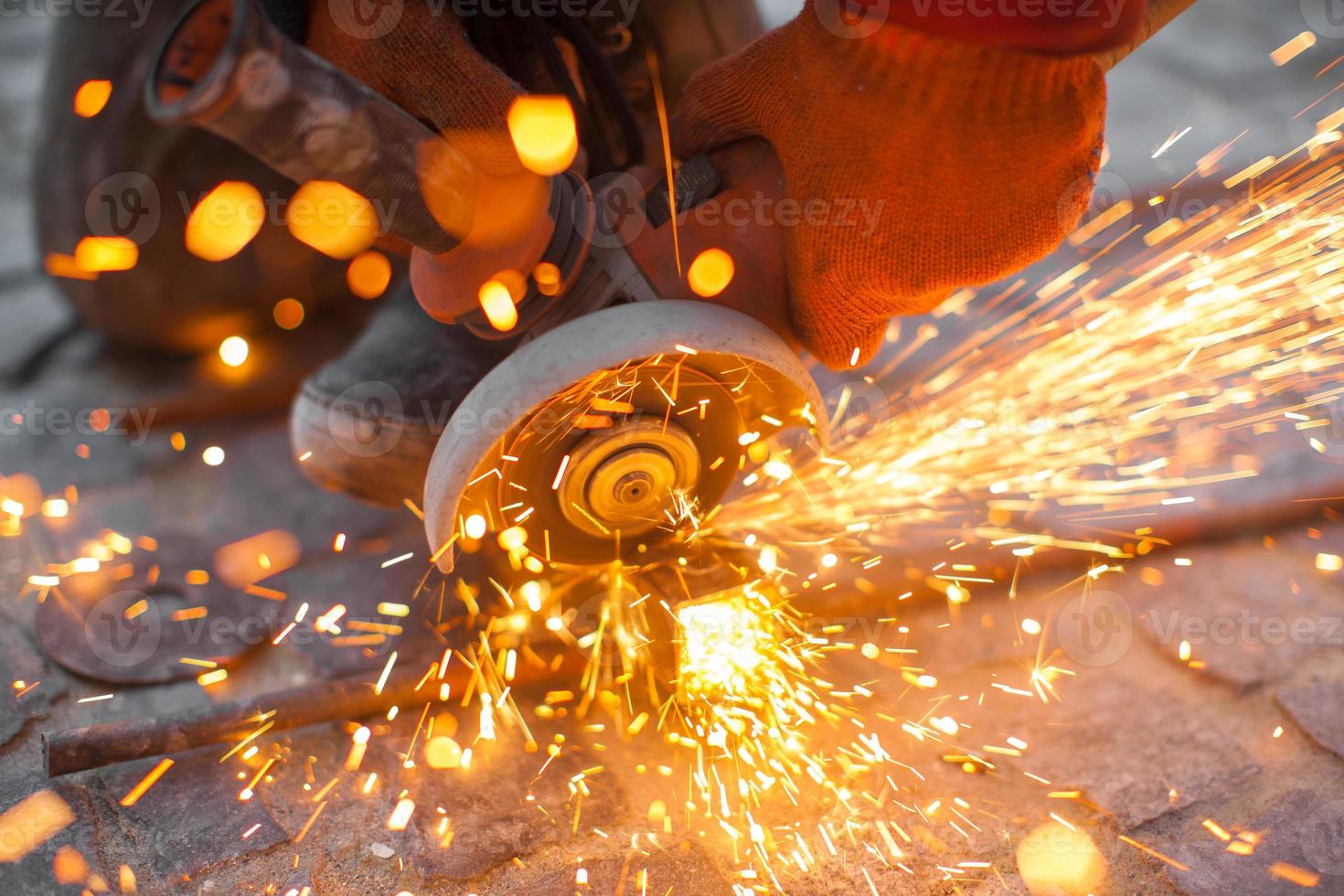 Angular grinding machine cuts metal with sparks photo