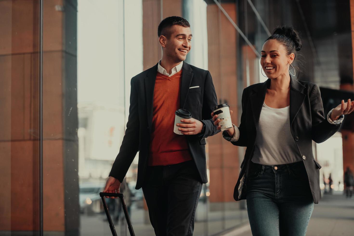 Business man and business woman talking and holding luggage traveling on a business trip photo