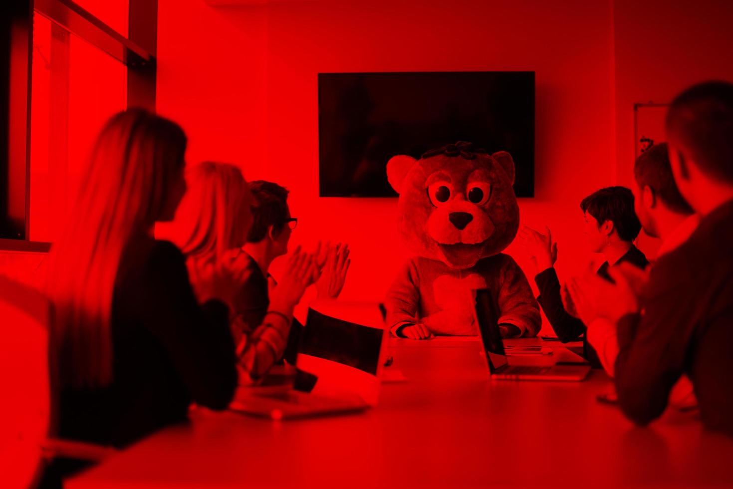 boss dresed as bear having fun with business people in trendy office photo