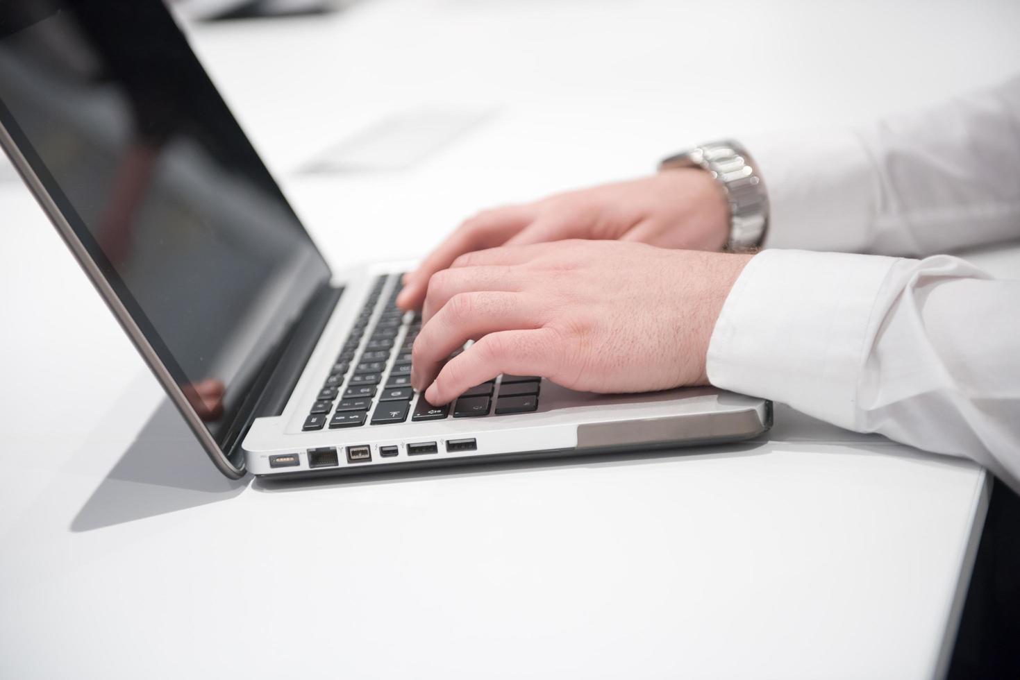 hands typing on laptop at meeting photo