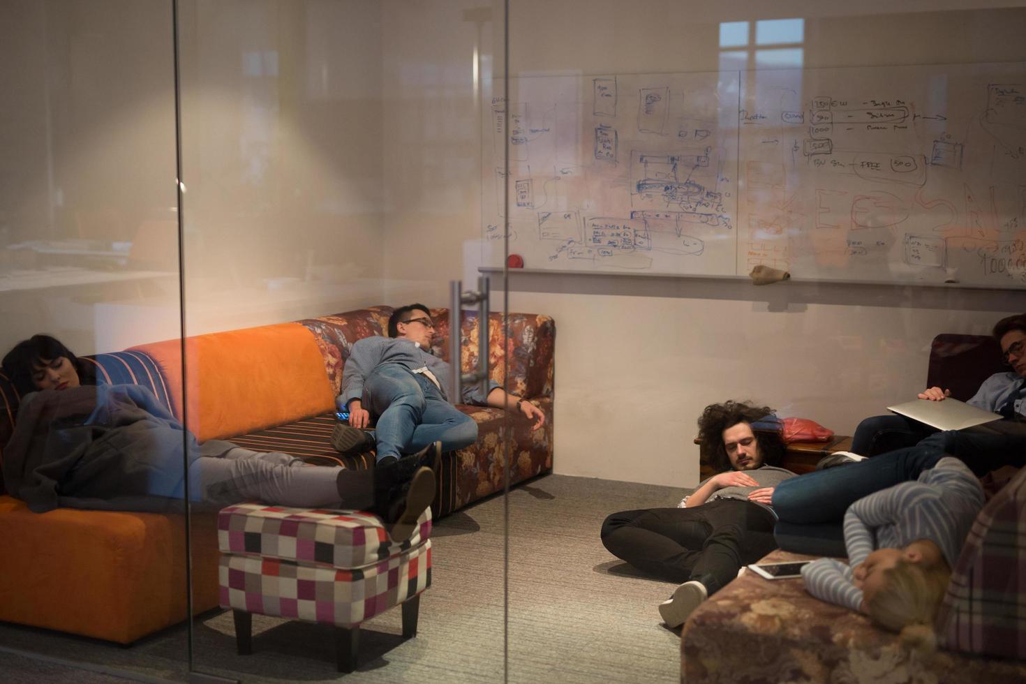 software developers sleeping on sofa in creative startup office photo