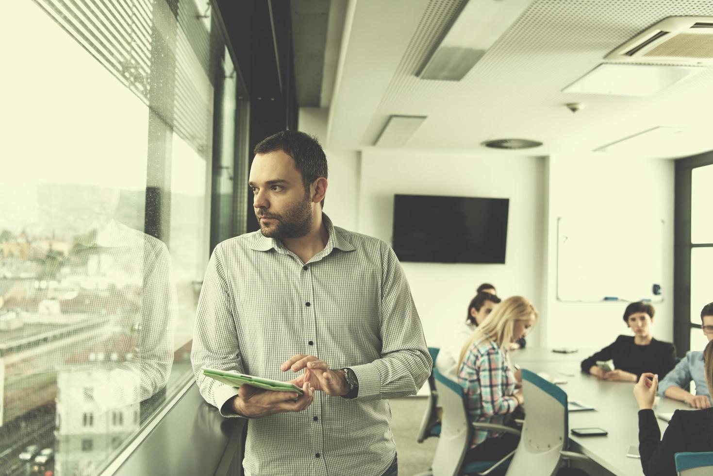 Businessman Using Tablet In Office Building by window photo