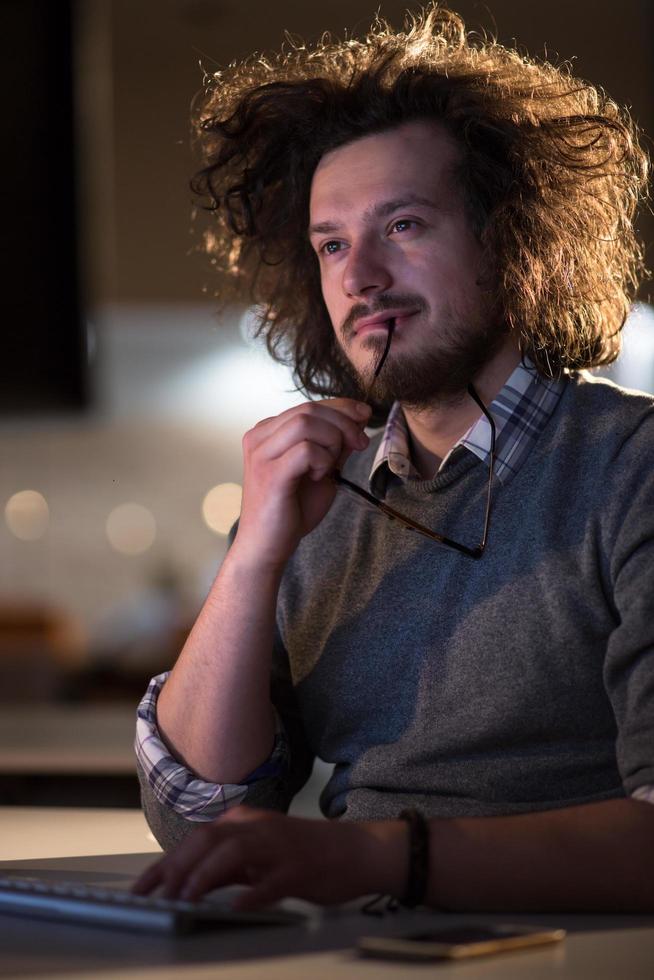 man working on computer in dark office photo