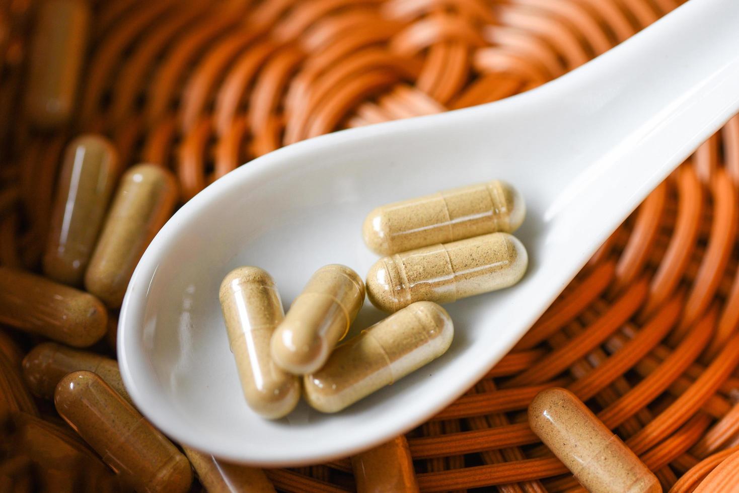 Herbal medicine extract from nature Non-toxic drug organic product on spoon - Herbal capsules from herbs healthy lifestyle photo