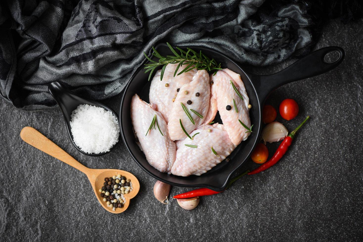 raw chicken wings food plate herbs and spices with pepper chili tomato garlic for cooking thai asian food rosemary chicken photo