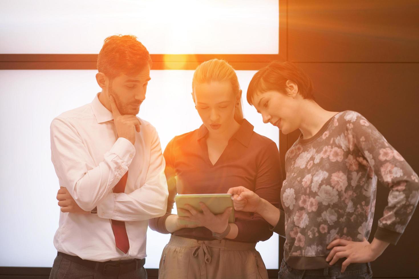 young business people group working on tablet computer with sunrise in background photo