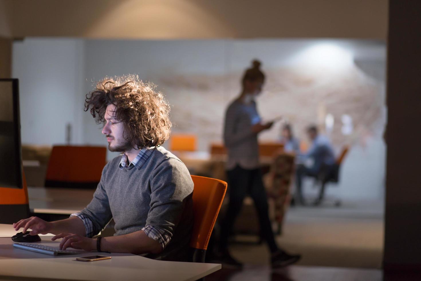 man working on computer in dark office photo