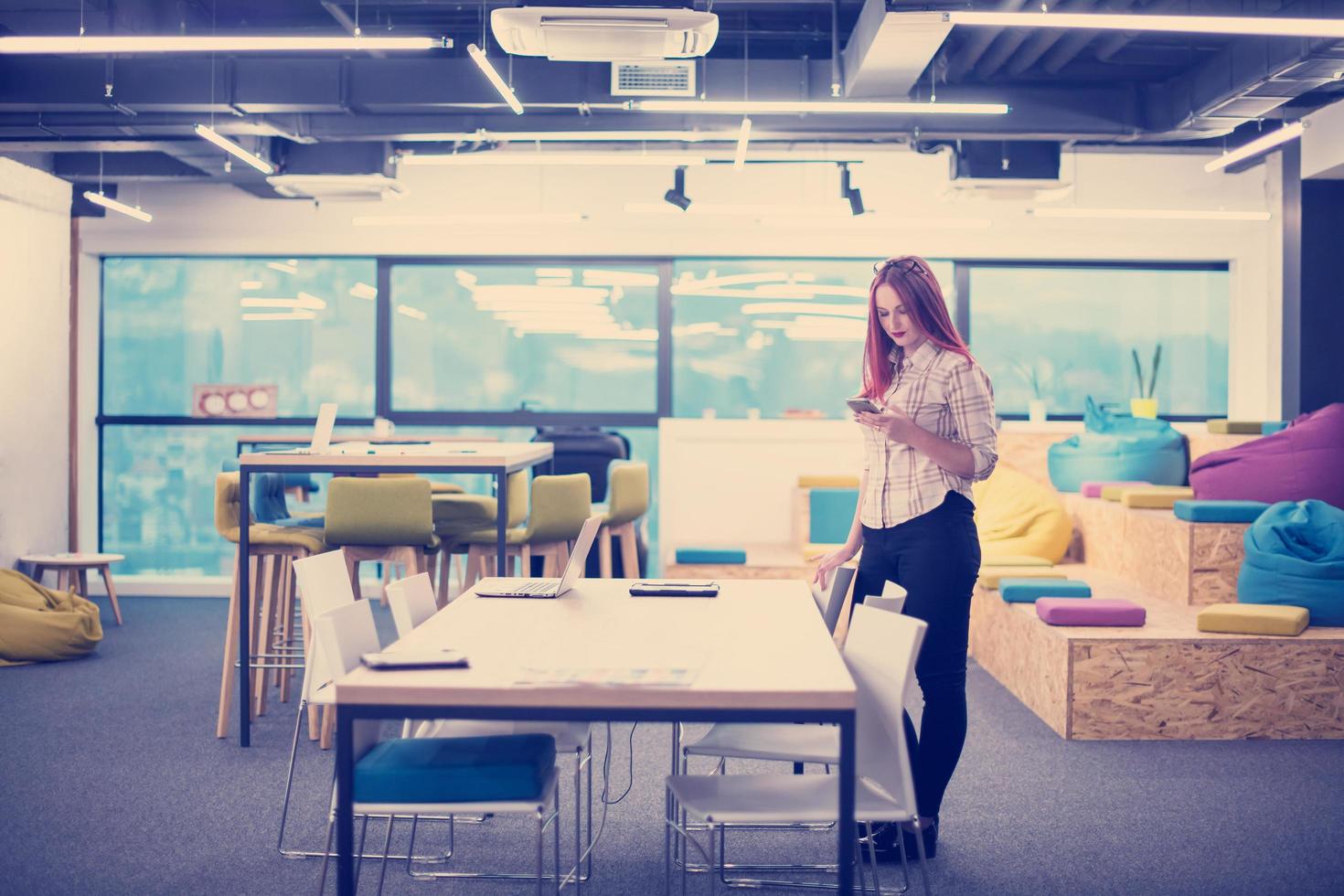 redhead businesswoman using mobile phone at office photo