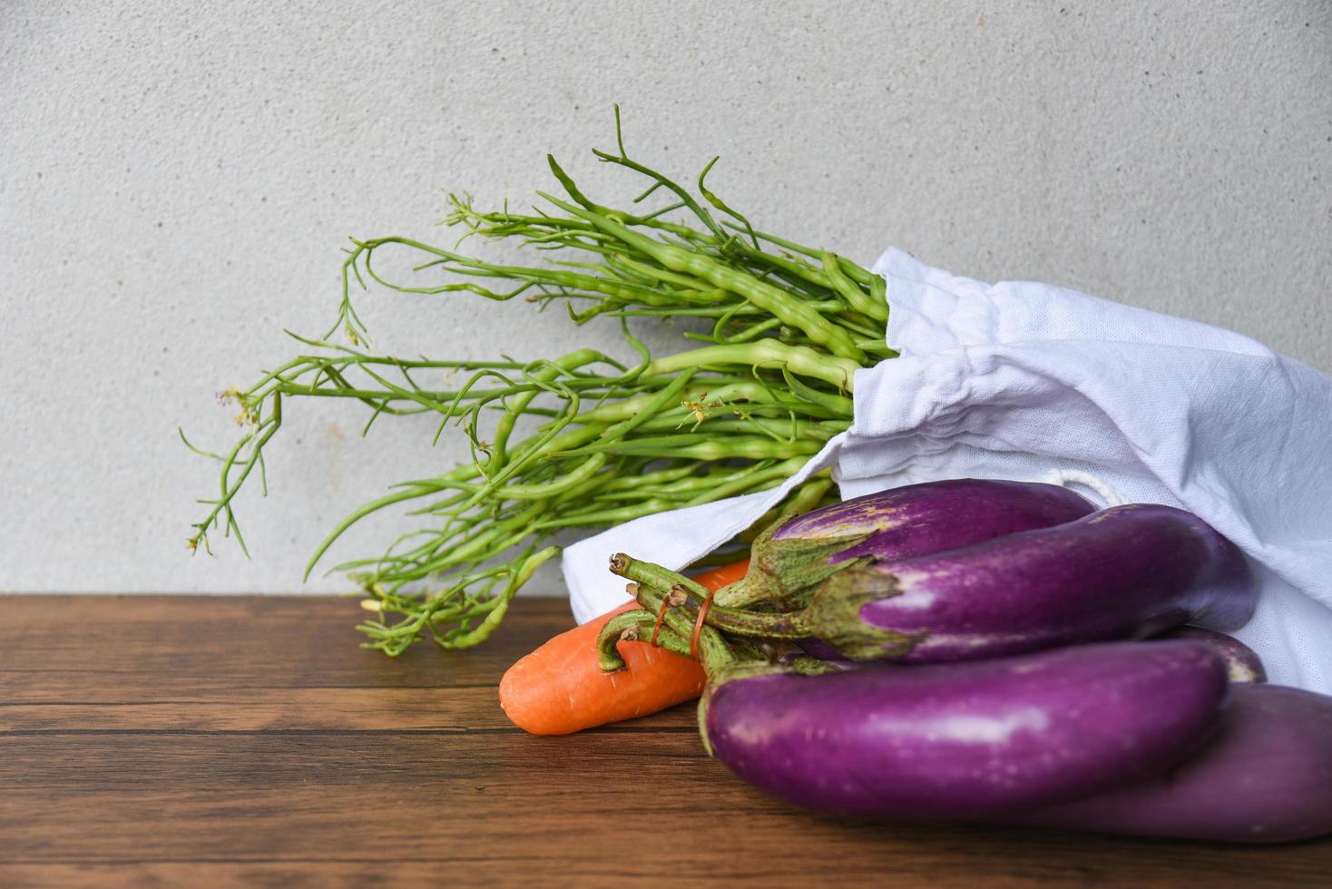 Zero waste use less plastic concept Fresh vegetables organic in eco cotton fabric bags on wooden table photo