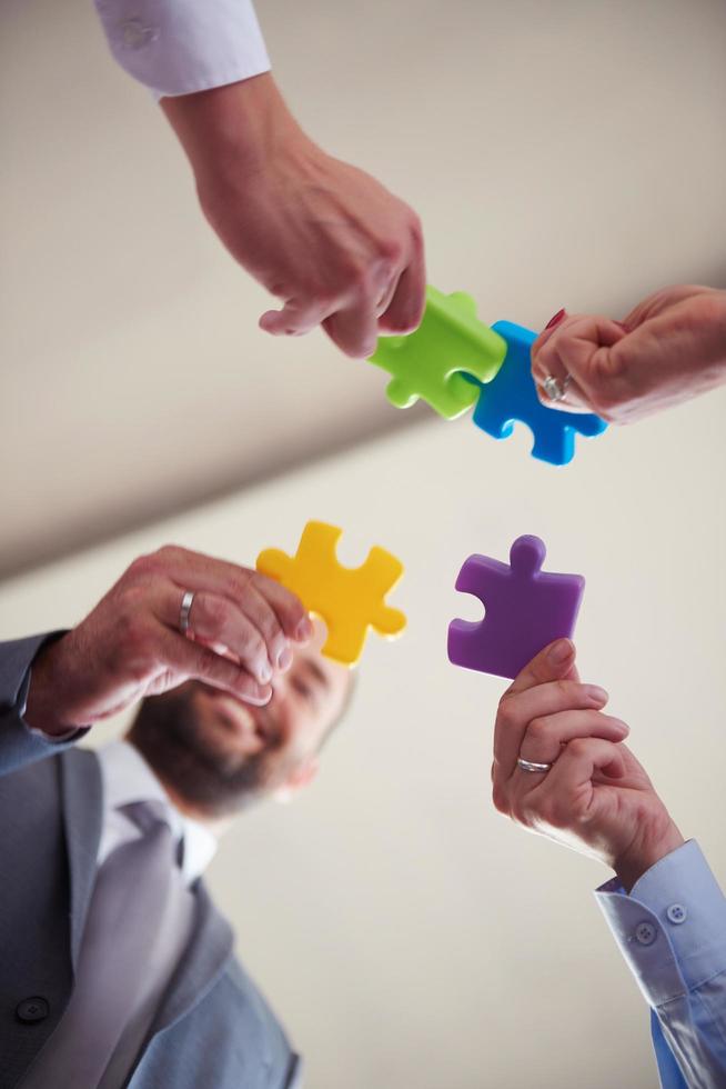 business people group assembling jigsaw puzzle photo