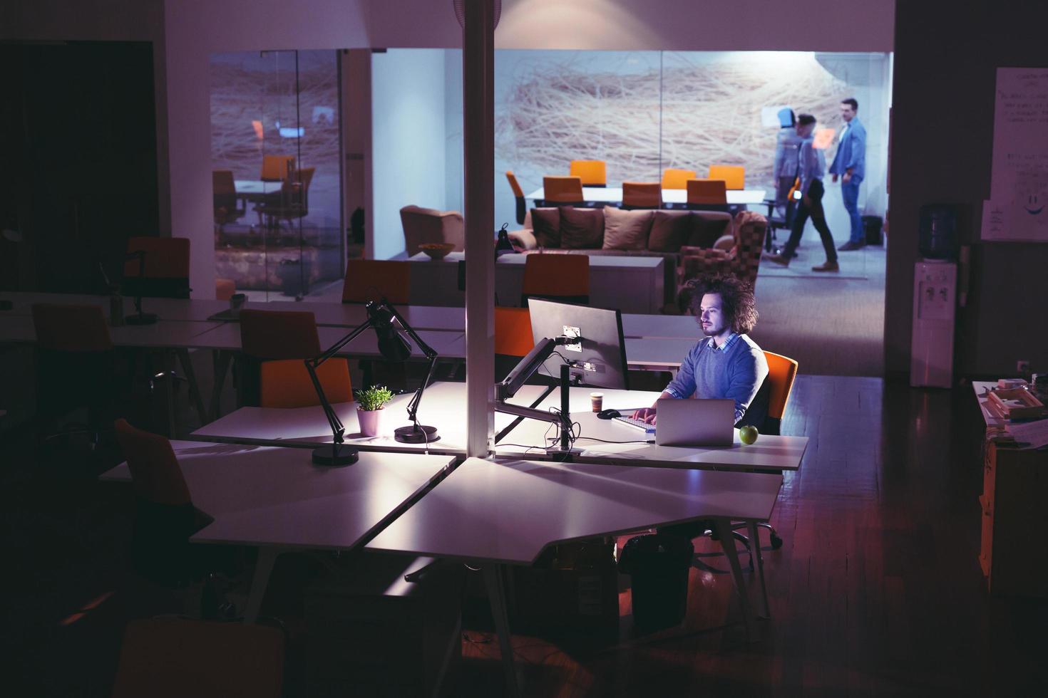 man working on computer in dark office photo