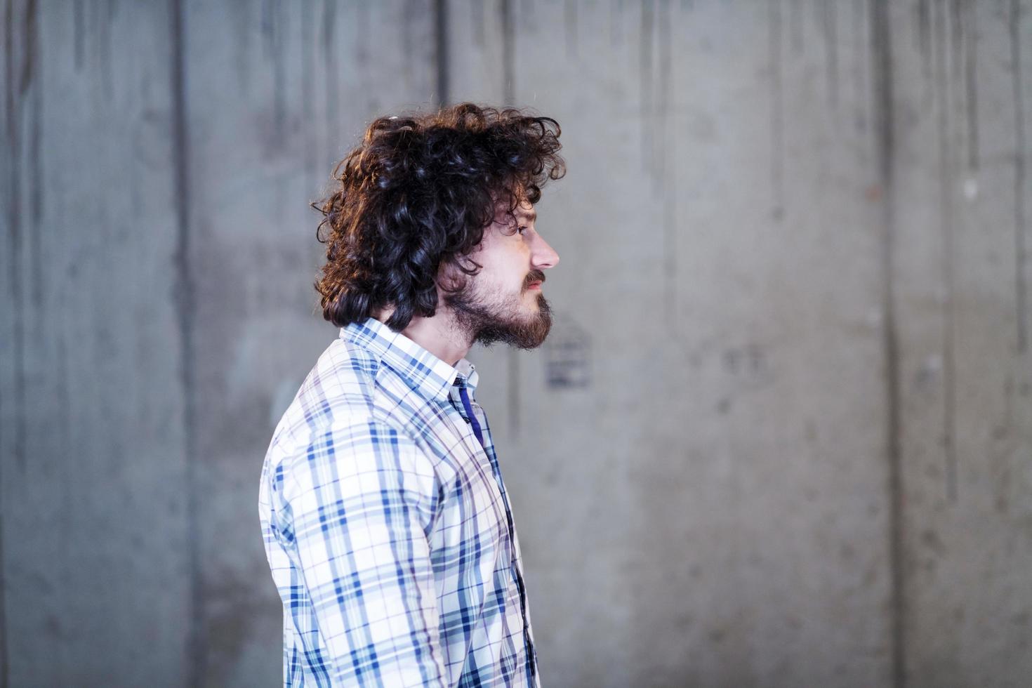 portrait of casual businessman in front of a concrete wall photo