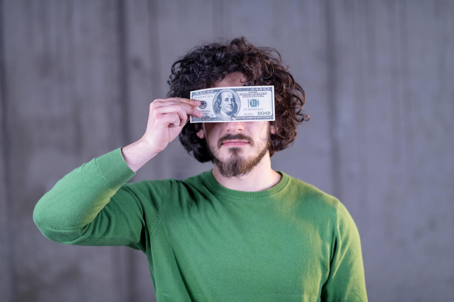 business man holding american dollar banknote over the eyes photo