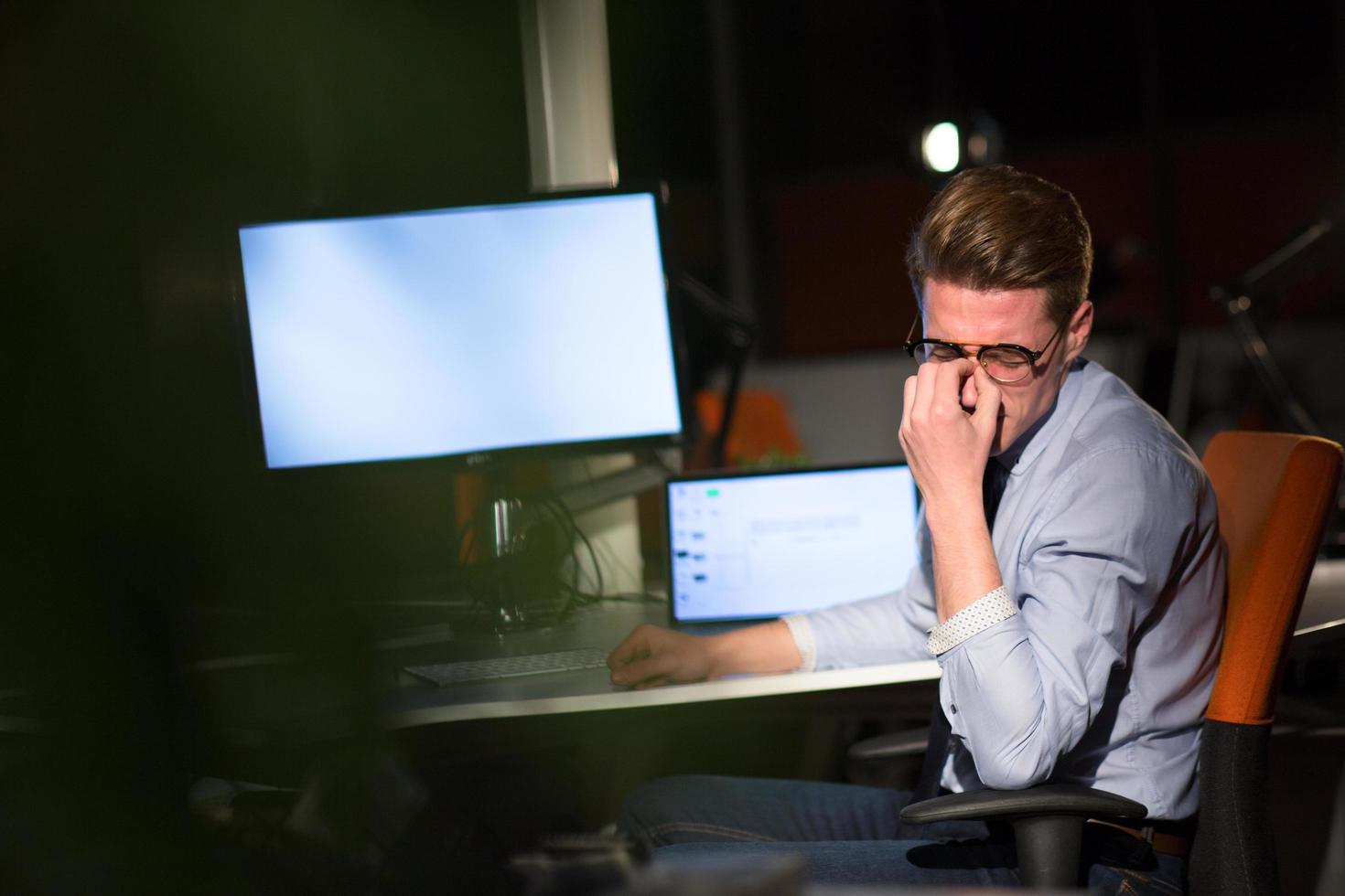 man working on computer in dark office photo