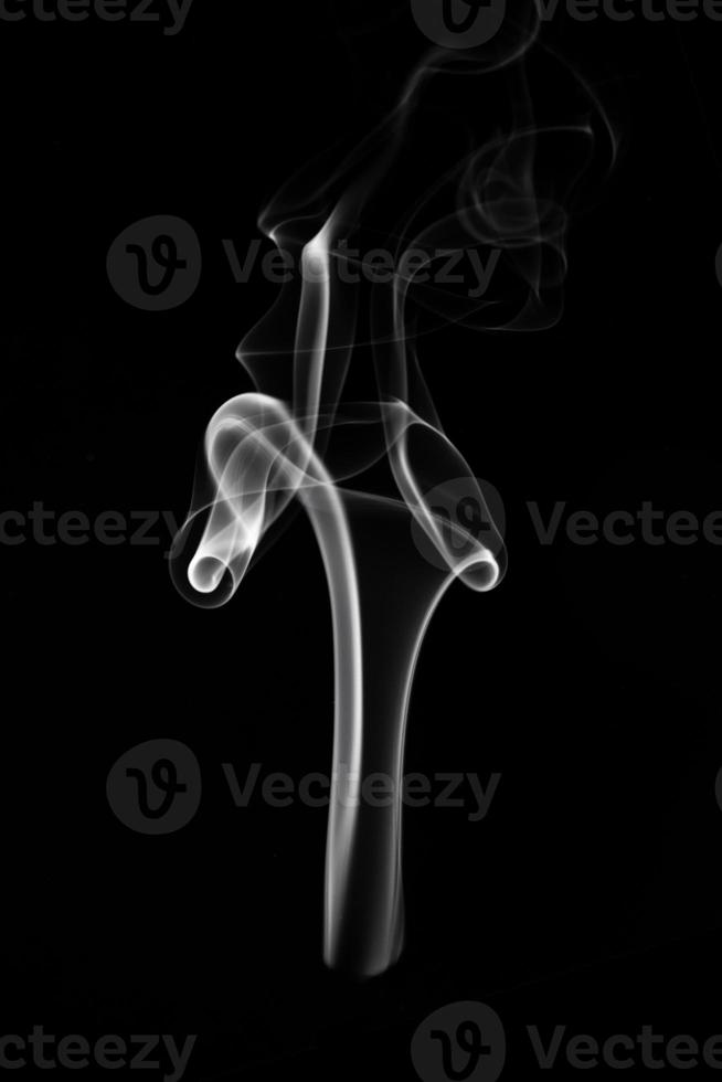 A single white smoke burn from incense, shot in studio with dark black background, for design and religion concept photo