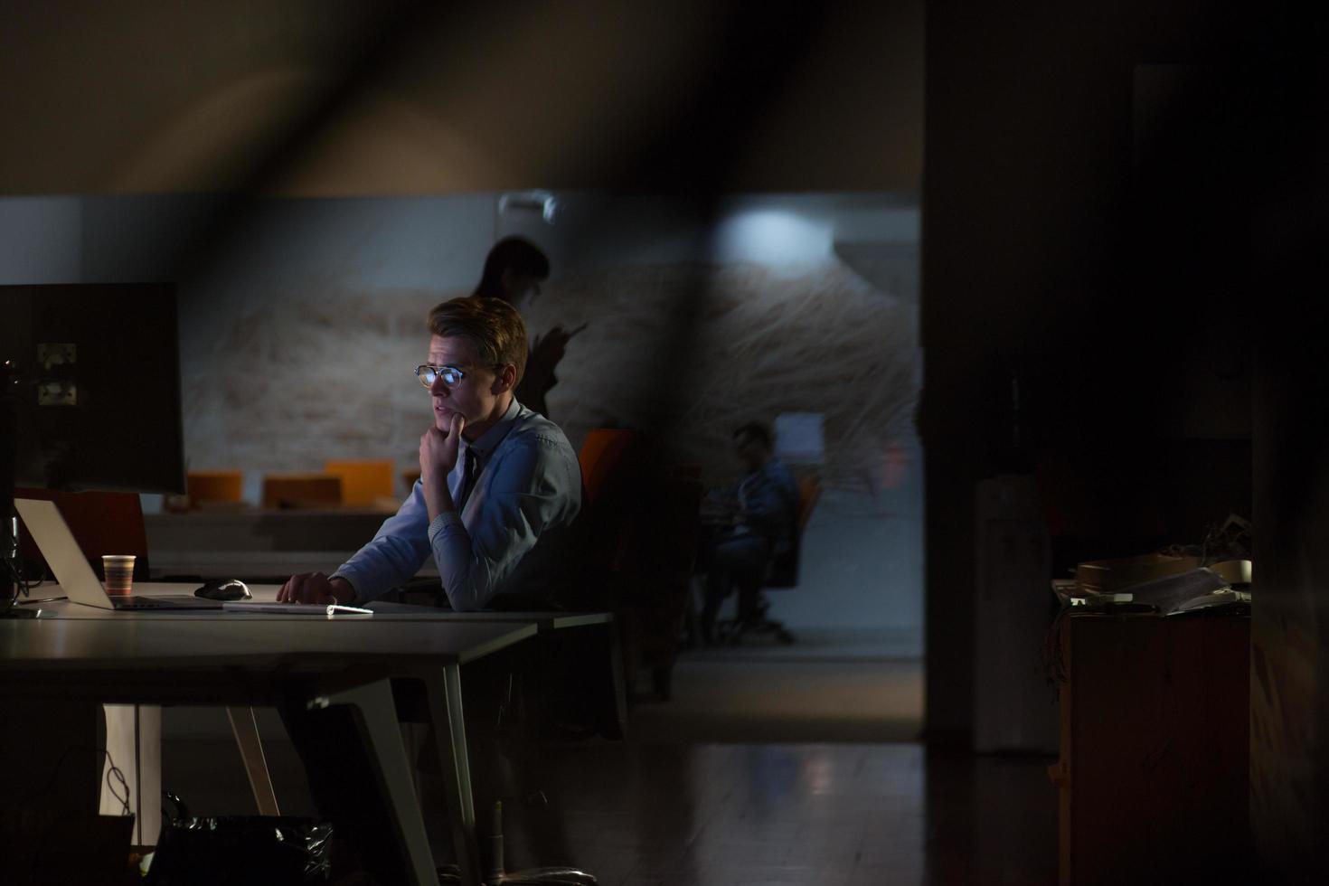man working on computer in dark office photo