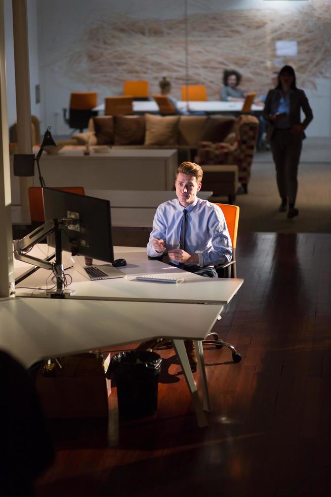 man working on computer in dark office photo