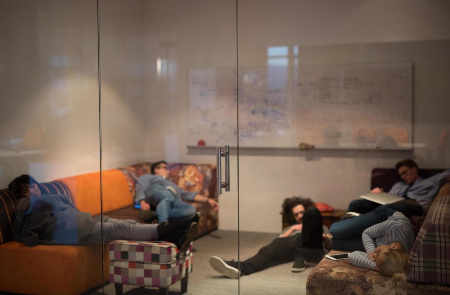 software developers sleeping on sofa in creative startup office photo