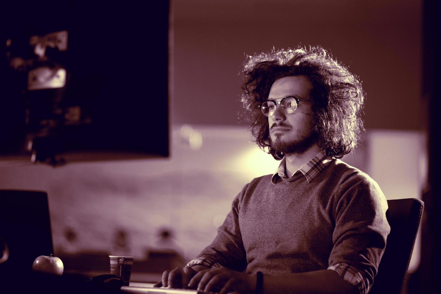 hombre trabajando en una computadora en una oficina oscura foto