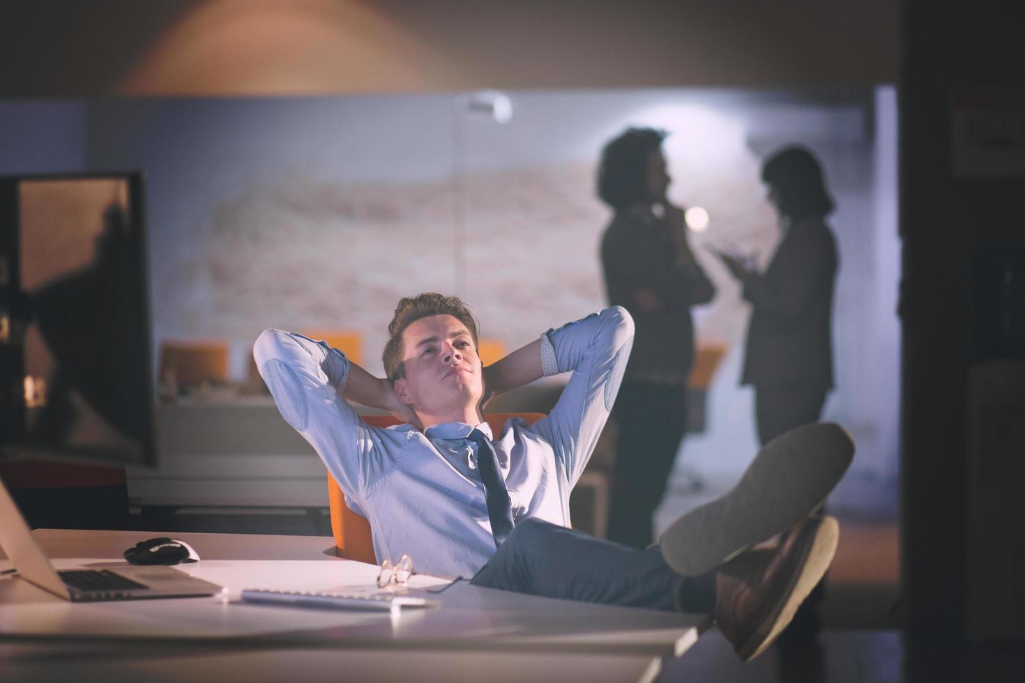 businessman sitting with legs on desk at office photo