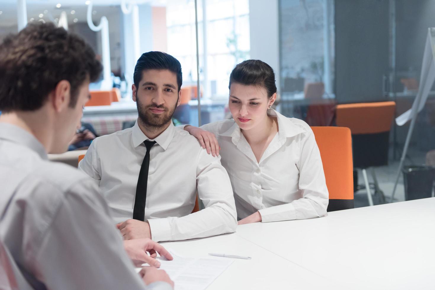 young couple signing contract documents on partners back photo