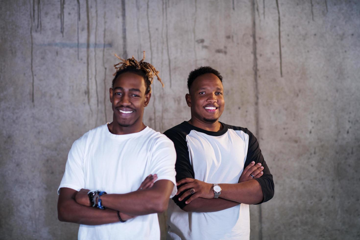 portrait of two black businessmen in front of a concrete wall photo