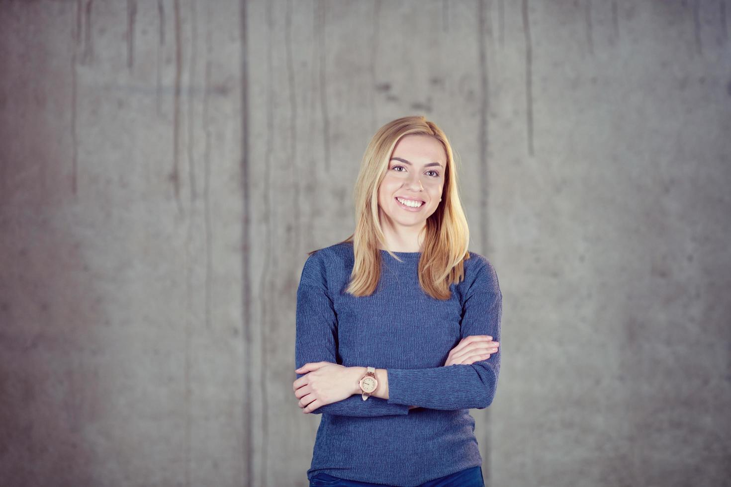 retrato de una mujer de negocios casual frente a un muro de hormigón foto