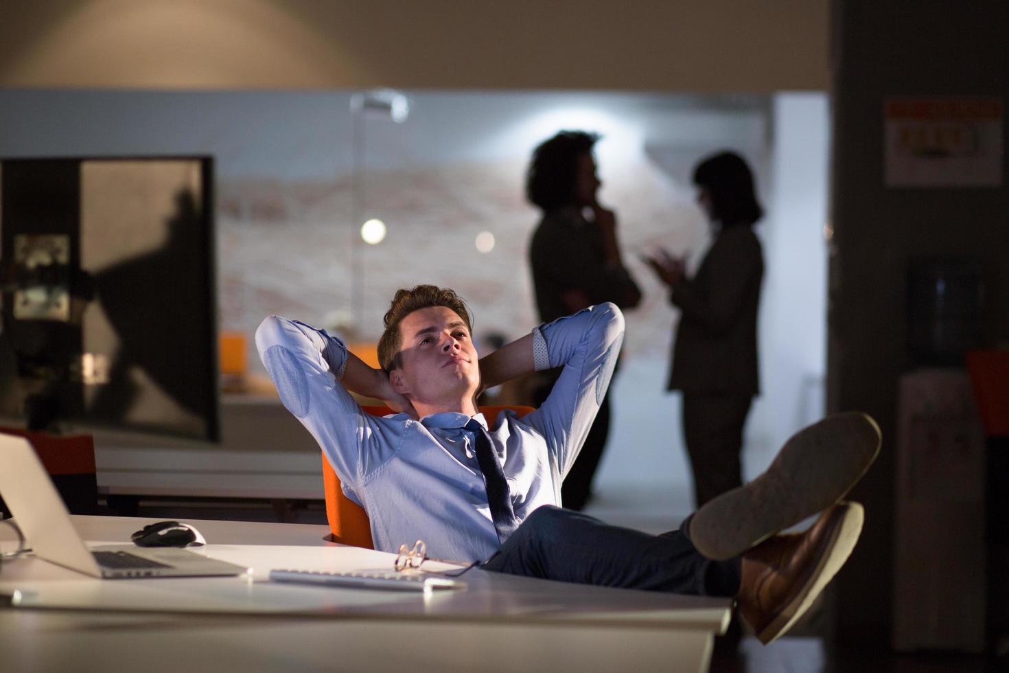 businessman sitting with legs on desk at office photo