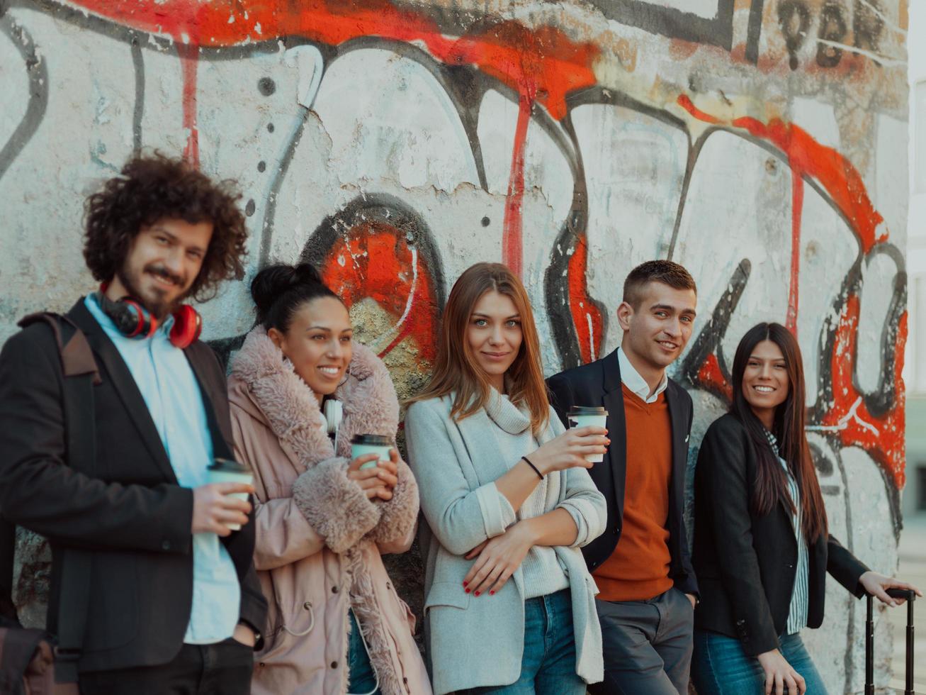 young people stand in front of a drawn wall in an abandoned street. photo