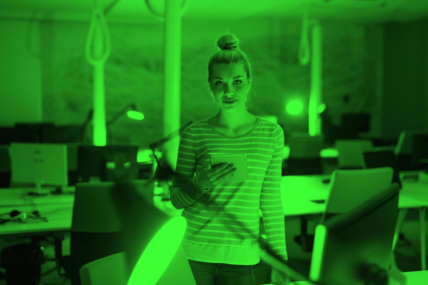 woman working on digital tablet in night office photo