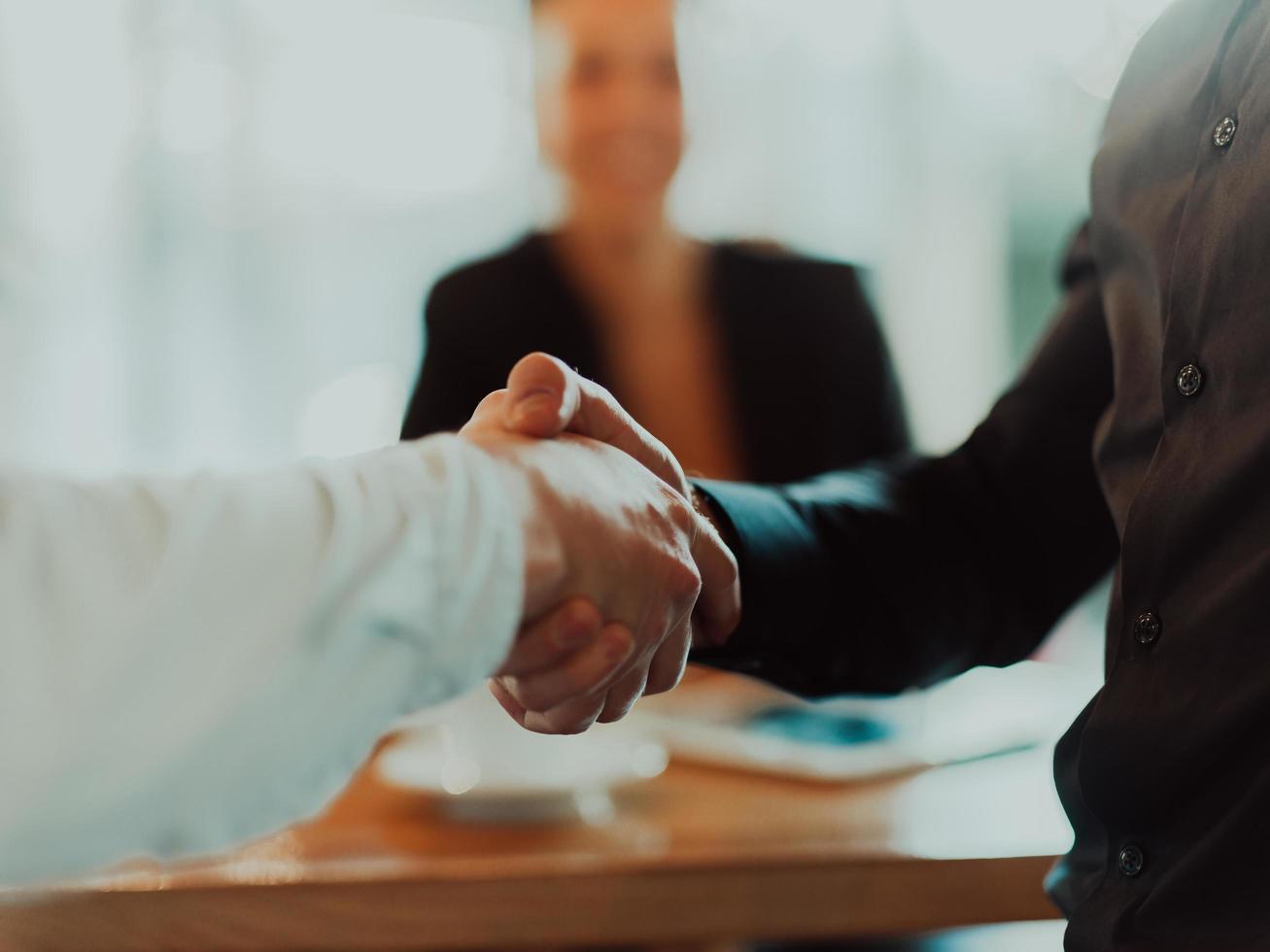 Business people or lawyers shaking hands finishing up meeting or negotiation in sunny office. photo