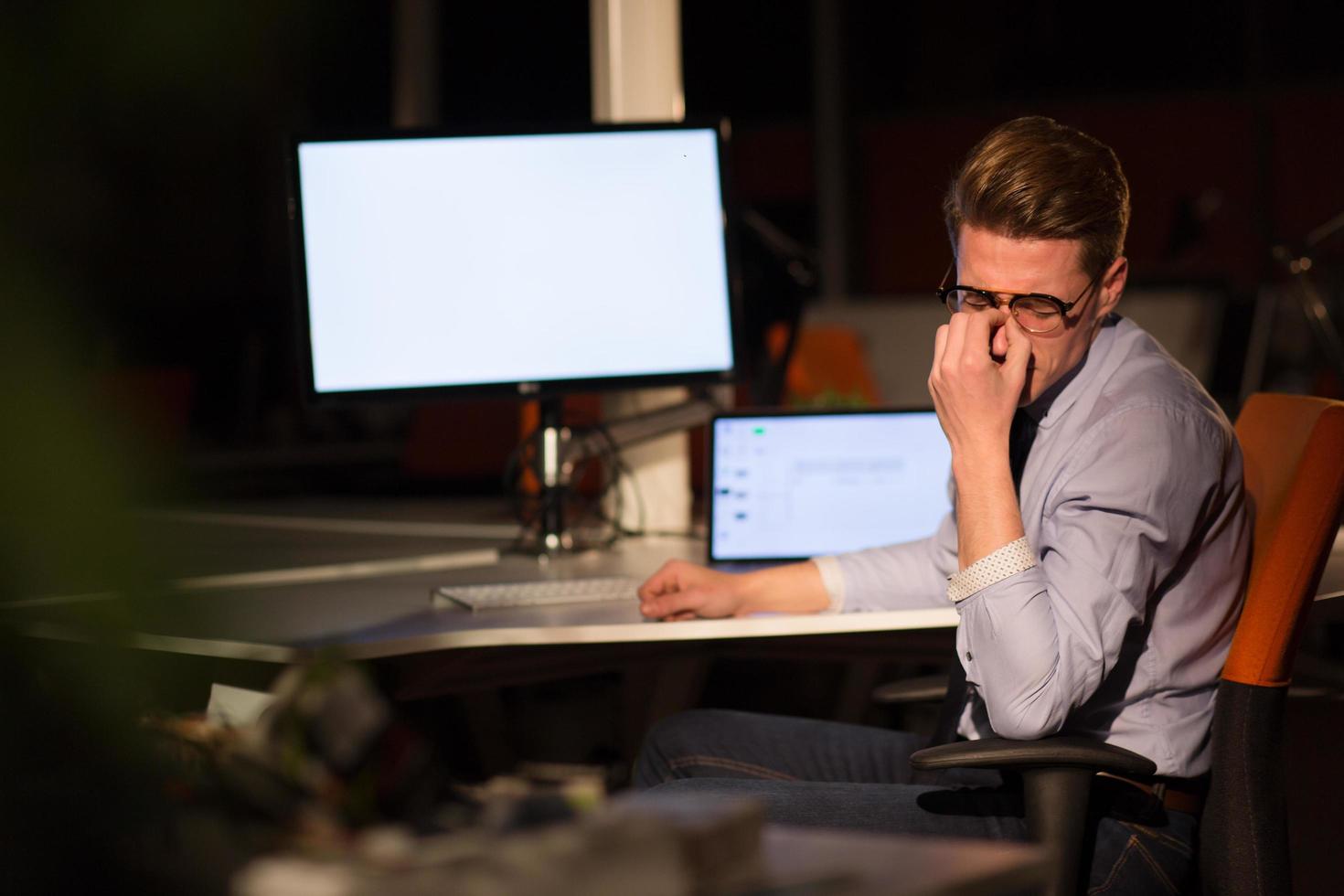man working on computer in dark office photo