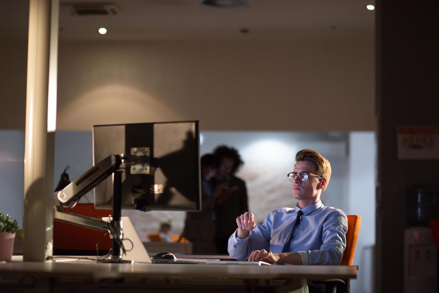 man working on computer in dark office photo