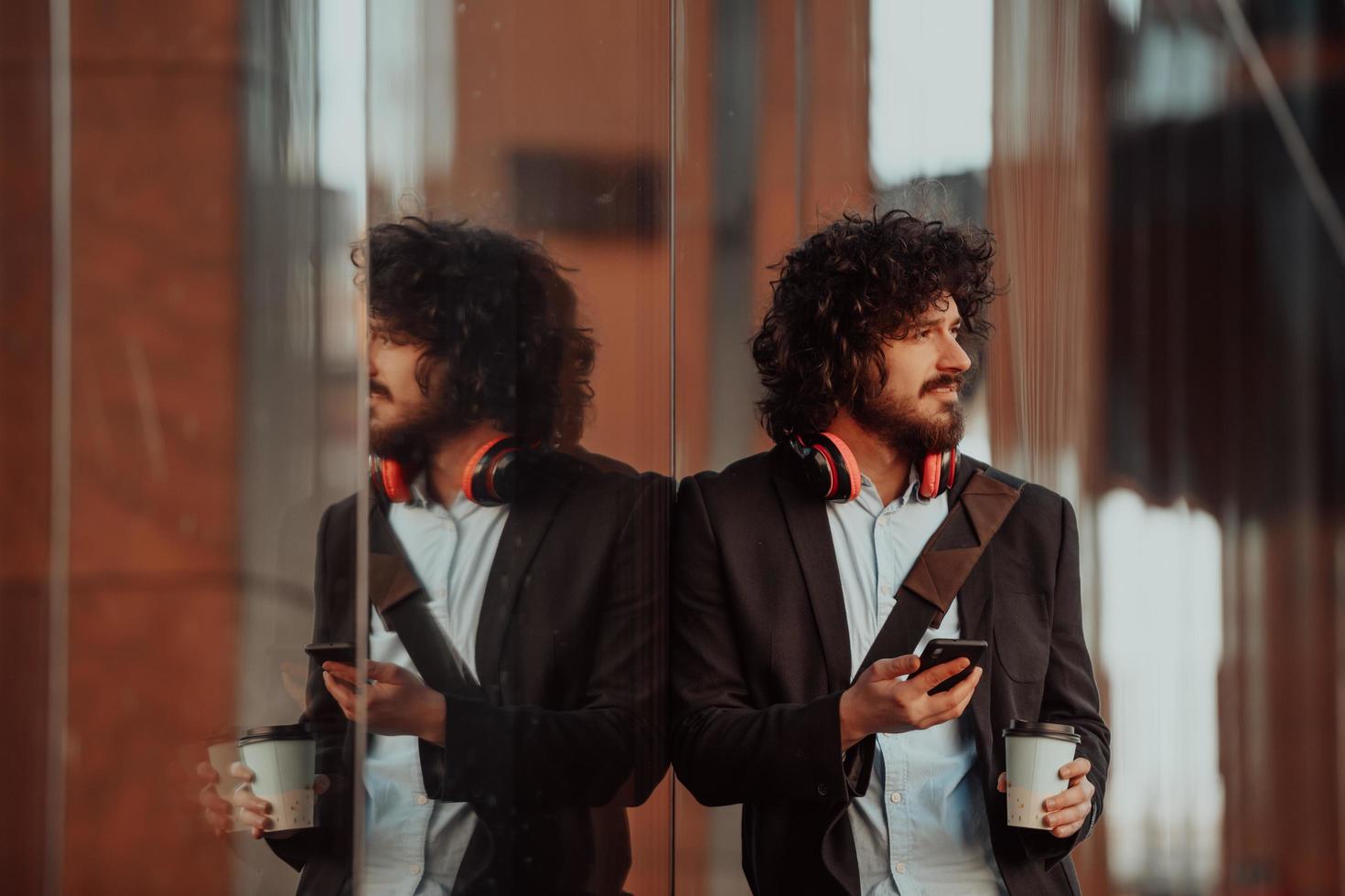 Happy young American holding a coffee. With headphones. Student boy. photo